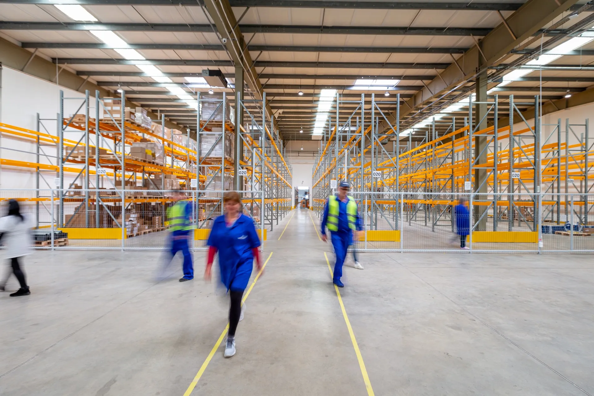 people walking inside empty warehouse