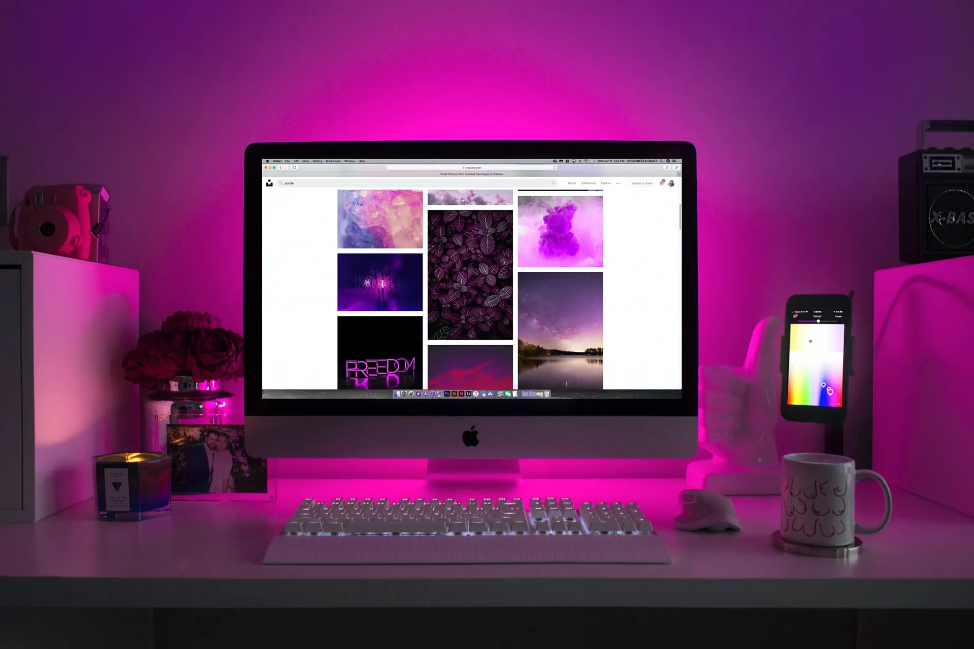 Imac computer on a desk with pink LED lights
